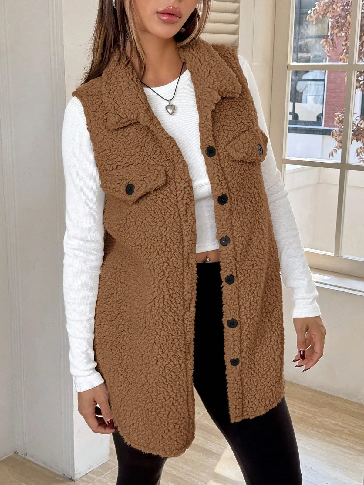Brown teddy fleece button-front vest with chest flap pockets over a white long-sleeve top, front view