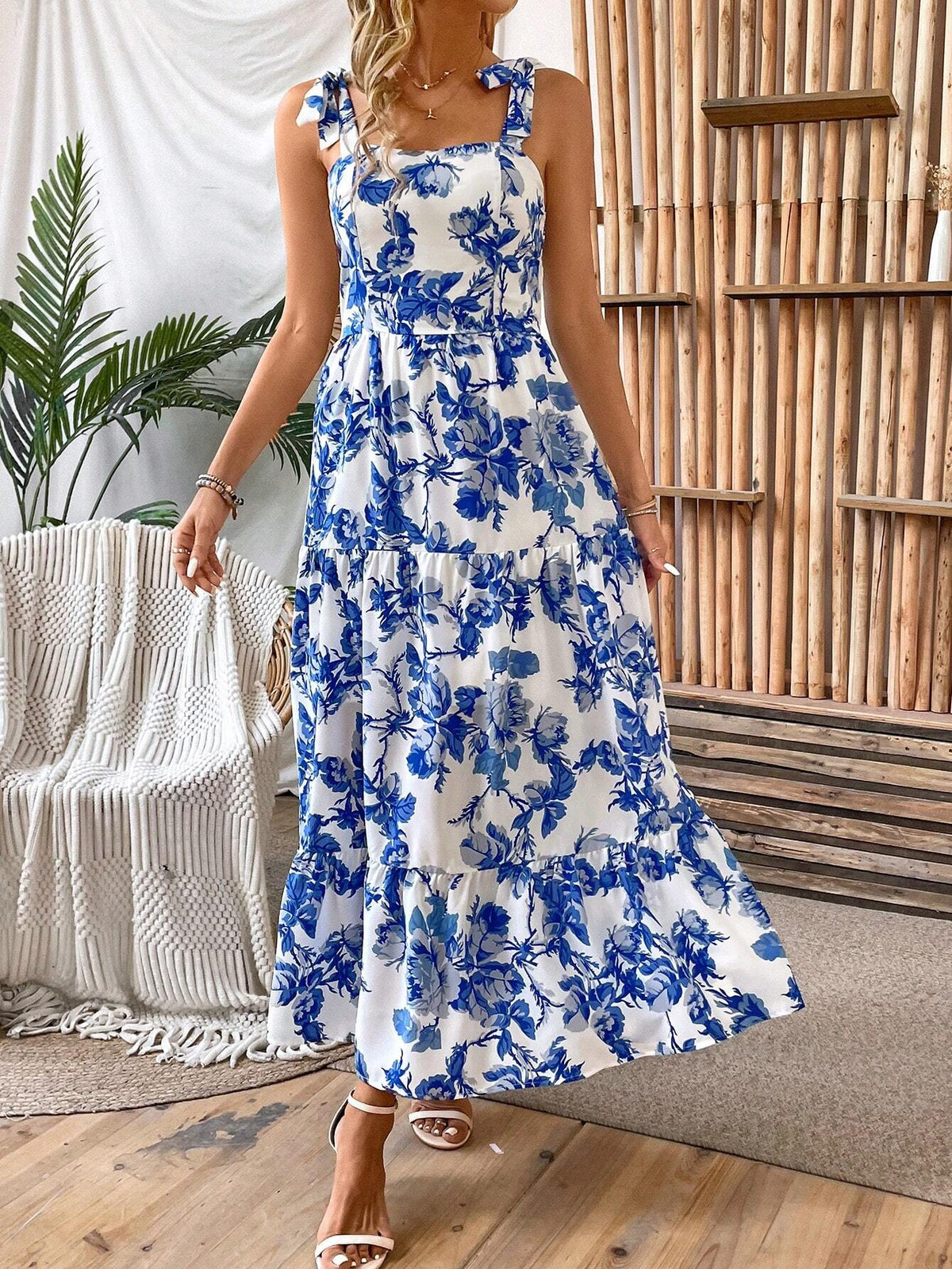 Woman wearing a blue and white floral tiered maxi dress with tie shoulder straps
