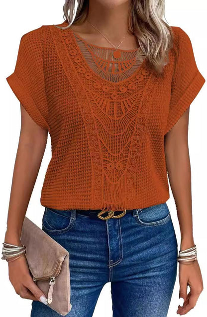 Woman wearing a rust orange waffle-knit tunic top with a crochet lace front and jeans