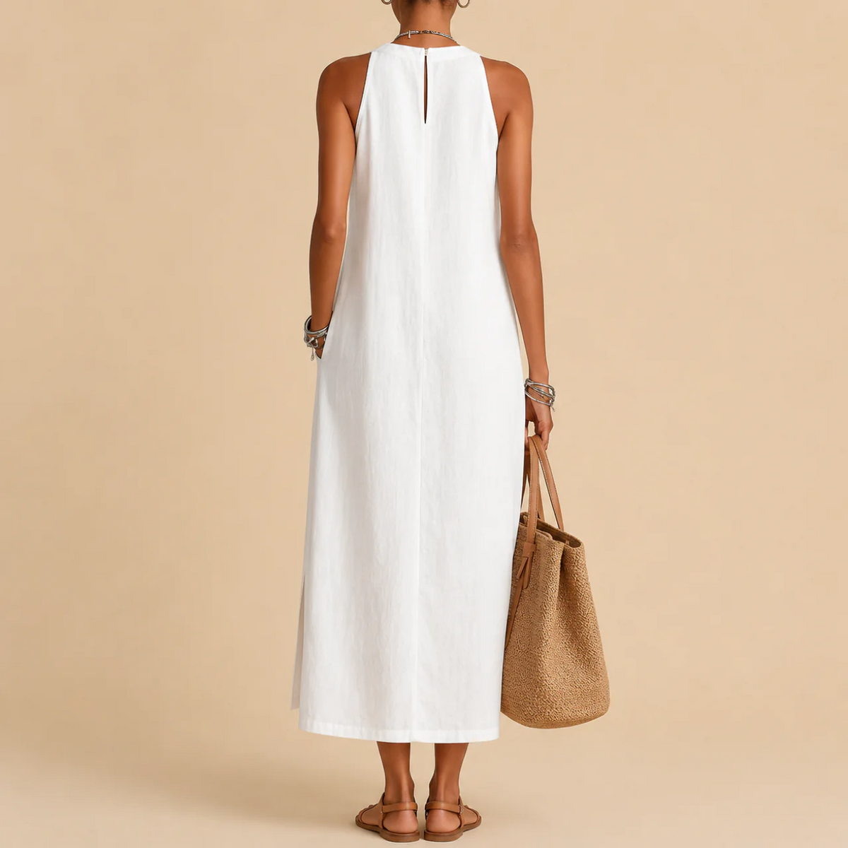 Back view of the white sleeveless dress with a keyhole closure at the neck, holding a tan tote bag