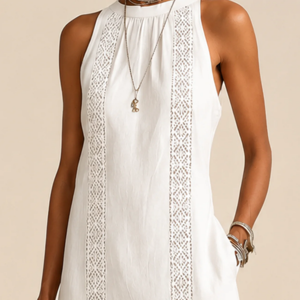 Close-up of the lace-trim panel and halter neckline of the white sleeveless dress