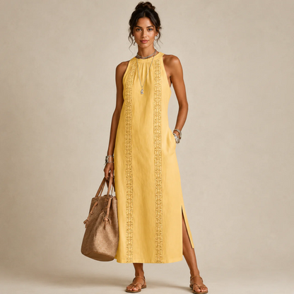 Woman wearing a yellow sleeveless halter-neck dress with a lace-trim center panel and a side slit, holding a tan tote bag