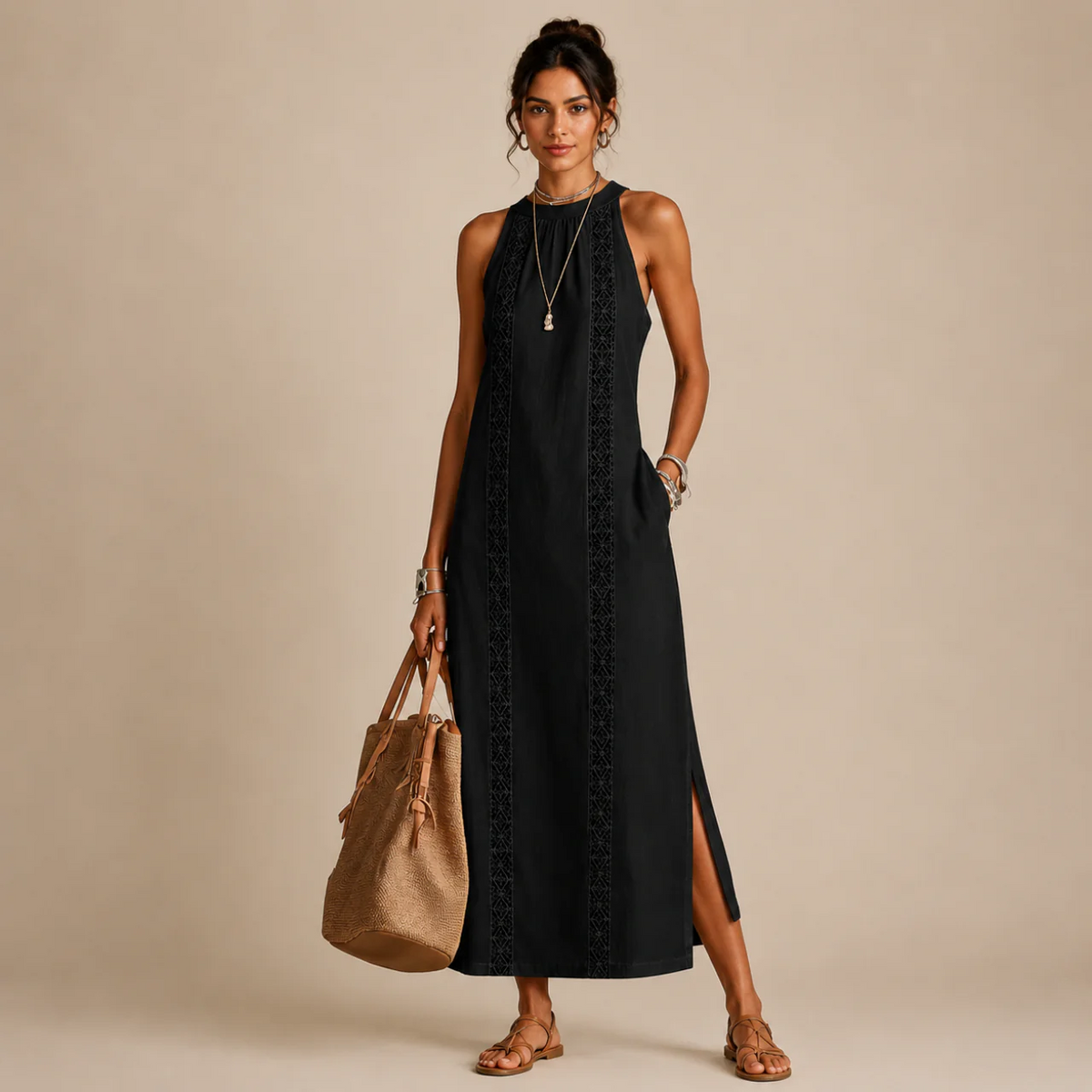 Woman wearing a black sleeveless halter-neck dress with a lace-trim center panel and a side slit, holding a tan tote bag