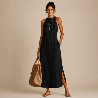 Woman wearing a black sleeveless halter-neck dress with a lace-trim center panel and a side slit, holding a tan tote bag
