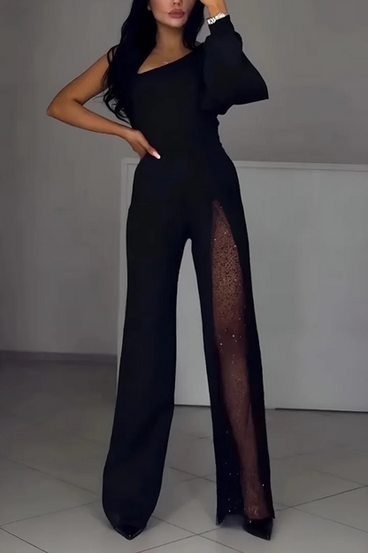 Woman wearing a black one-shoulder jumpsuit with a sheer mesh panel down one leg, front view