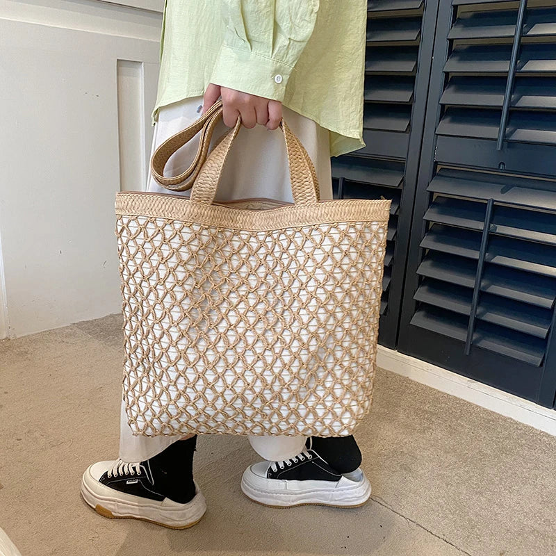 Woman holding the beige open-weave tote bag by its handles