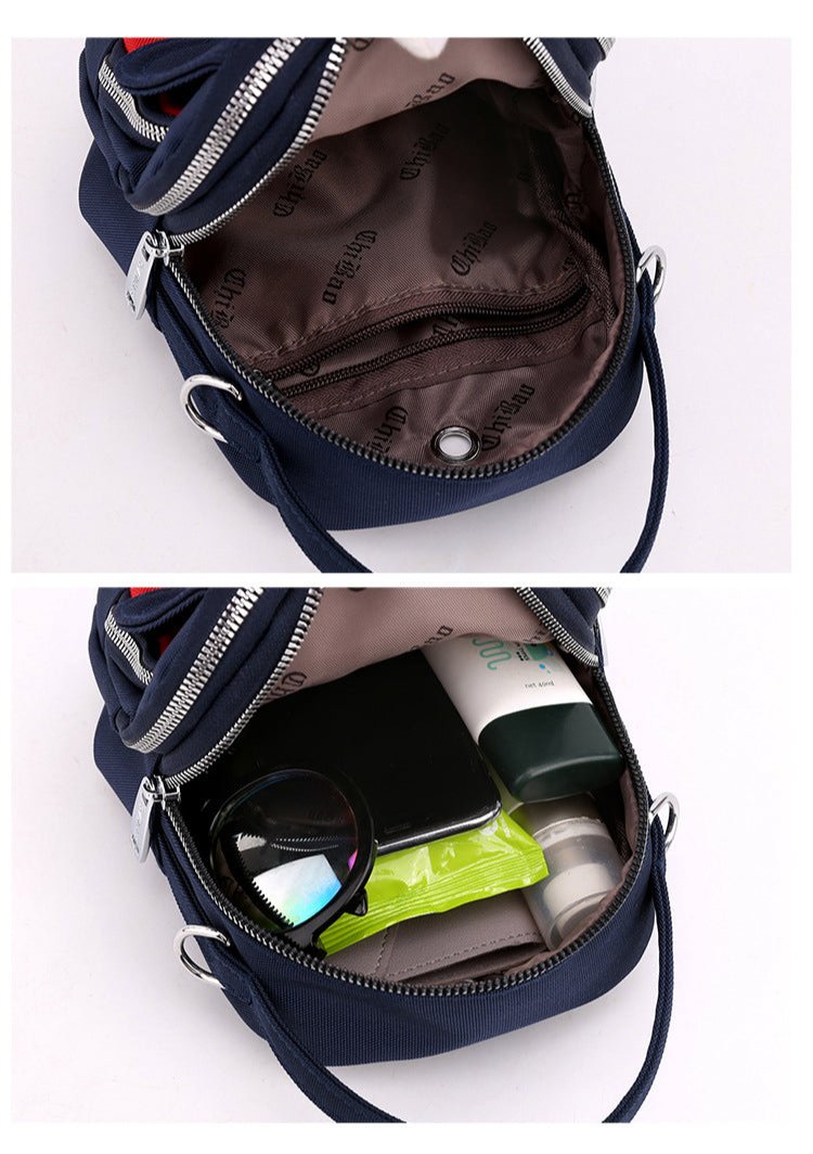 Inside of the navy shoulder bag, empty and holding a phone, sunglasses and small items
