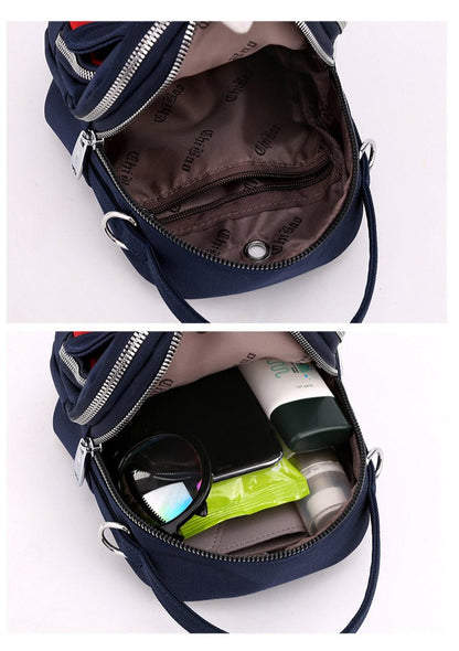 Inside of the navy shoulder bag, empty and holding a phone, sunglasses and small items