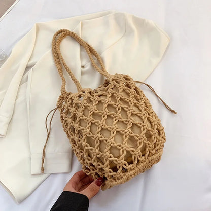 Beige knotted-rope beach bag with drawstring inner lining, laid on a white top