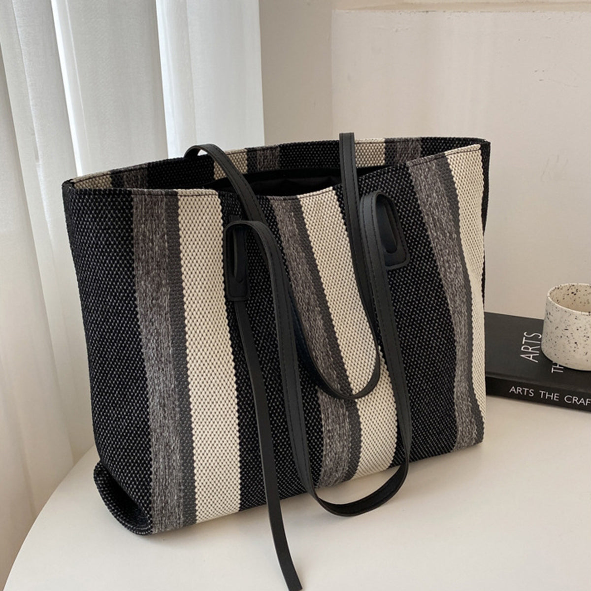 Black, gray and white striped canvas tote with black faux leather handles
