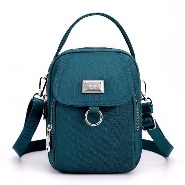 Small teal shoulder bag with front flap pocket, front view