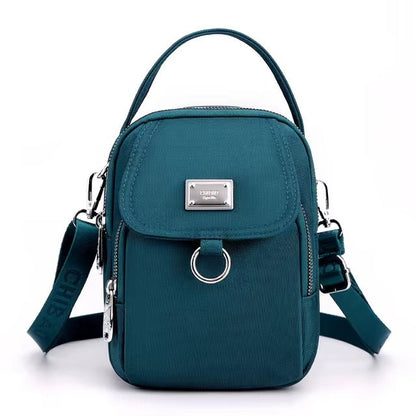 Small teal shoulder bag with front flap pocket, front view