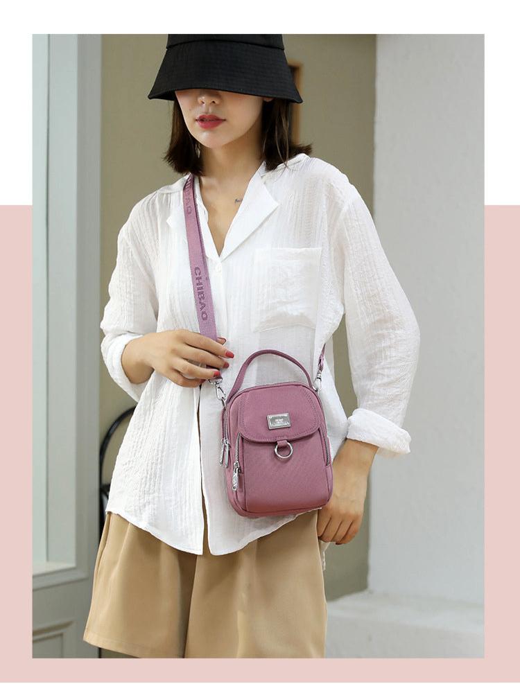 Woman wearing the small mauve pink shoulder bag crossbody, front view