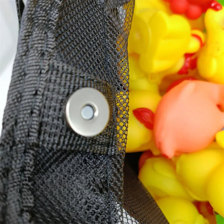 Close-up of the black mesh fabric and metal snap closure, with colorful toys seen through the mesh
