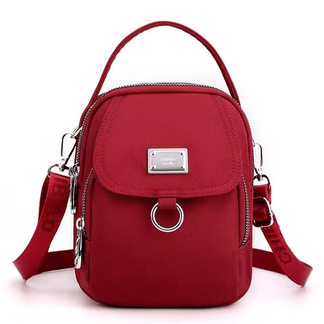 Small red shoulder bag with front flap pocket, front view