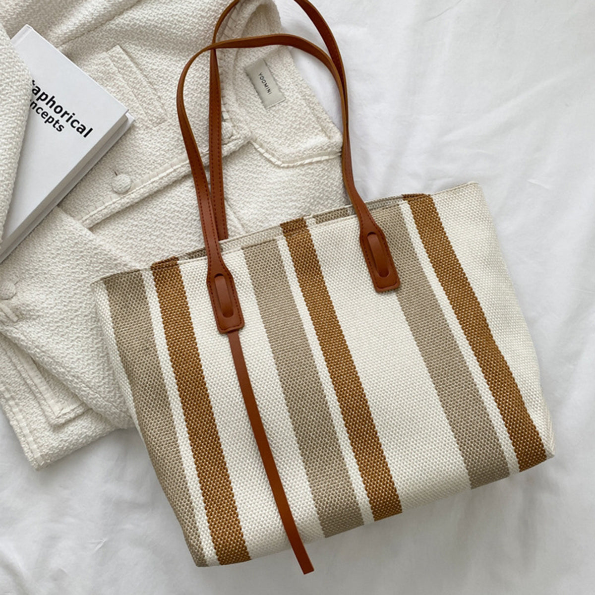 Brown and cream striped canvas tote laid flat on a white jacket