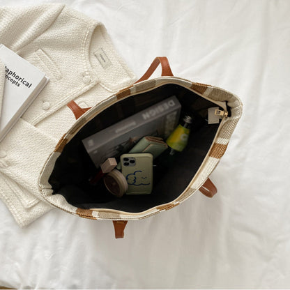 Open striped canvas tote showing the black lining holding a phone, book and everyday items