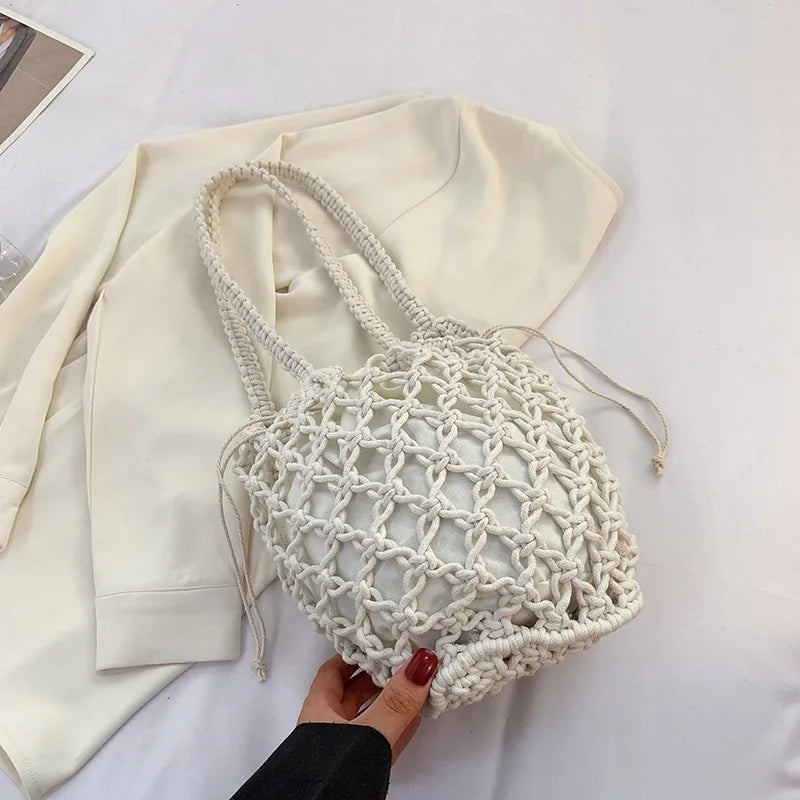 White knotted-rope beach bag with drawstring inner lining, laid on a white top