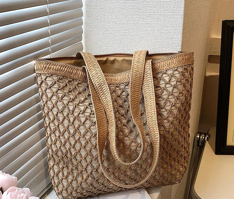 Brown open-weave tote bag with long handles, standing on a table