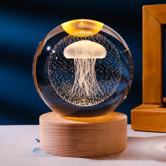 Crystal ball night light with a jellyfish design inside, on a wooden base