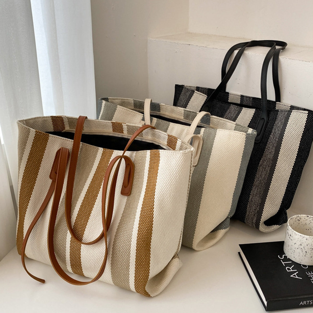 Three striped canvas tote bags in brown, gray and black, with long handles