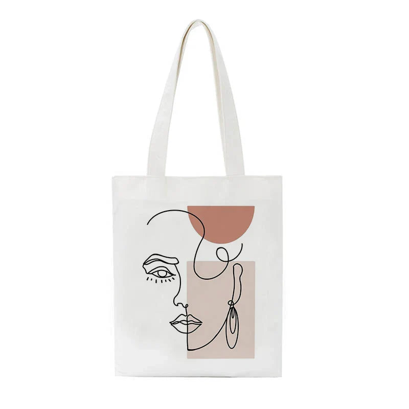 White canvas bag with a line-art face print on a white background