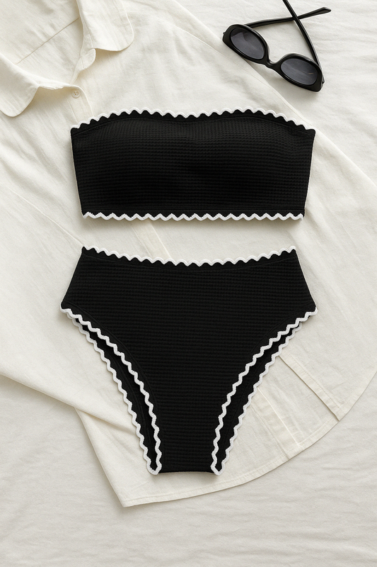 Black textured bandeau bikini set with white wavy trim, laid flat