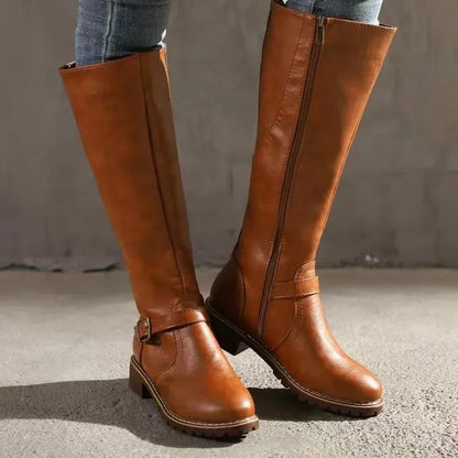 Tan brown knee-high boots with a buckle strap and side zipper, worn with jeans