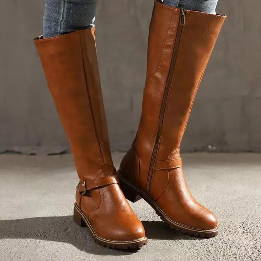 Tan brown knee-high boots with a buckle strap and side zipper, worn with jeans