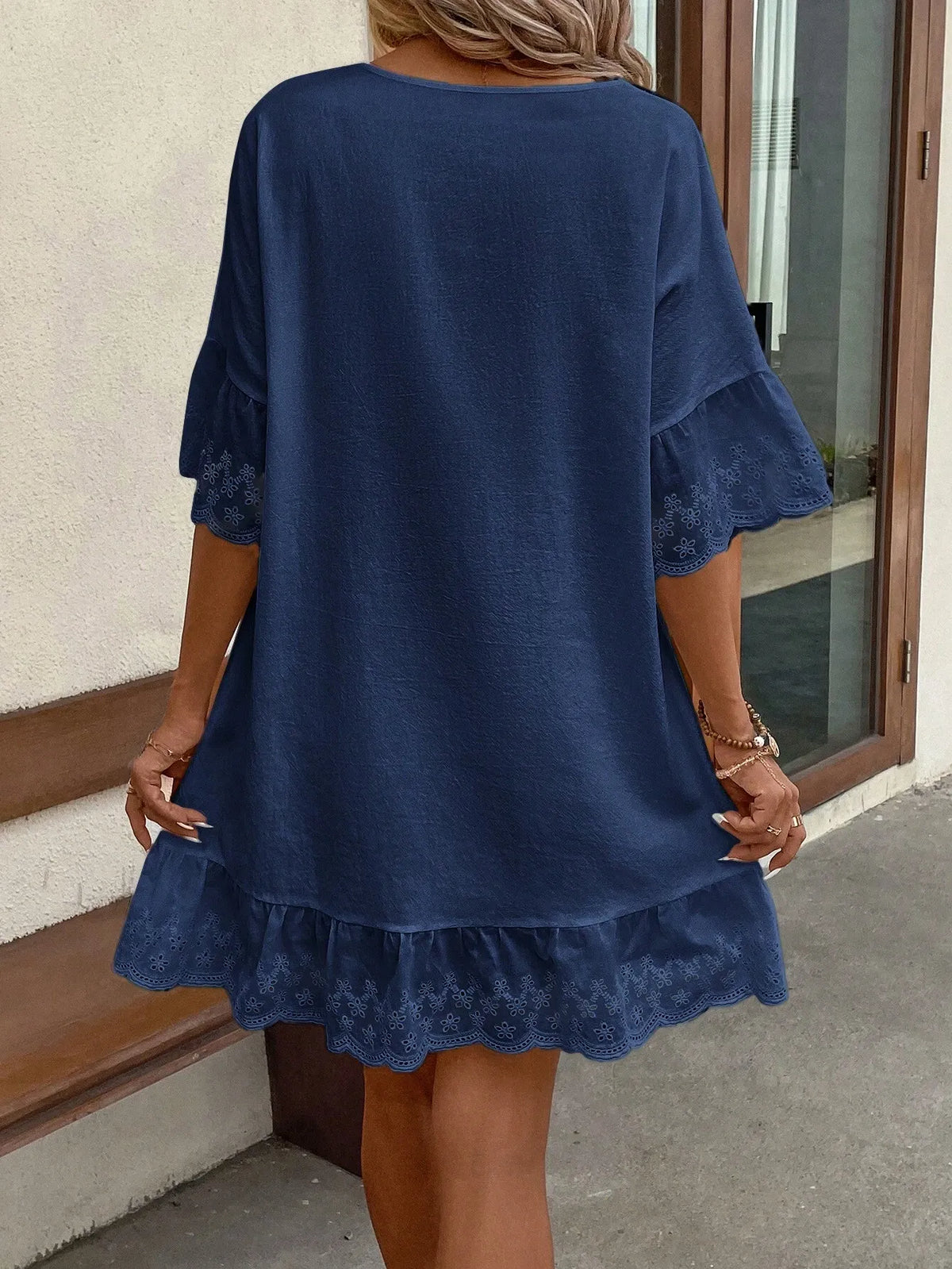 Front view of the navy blue V-neck dress with a lace-trimmed hem and short sleeves
