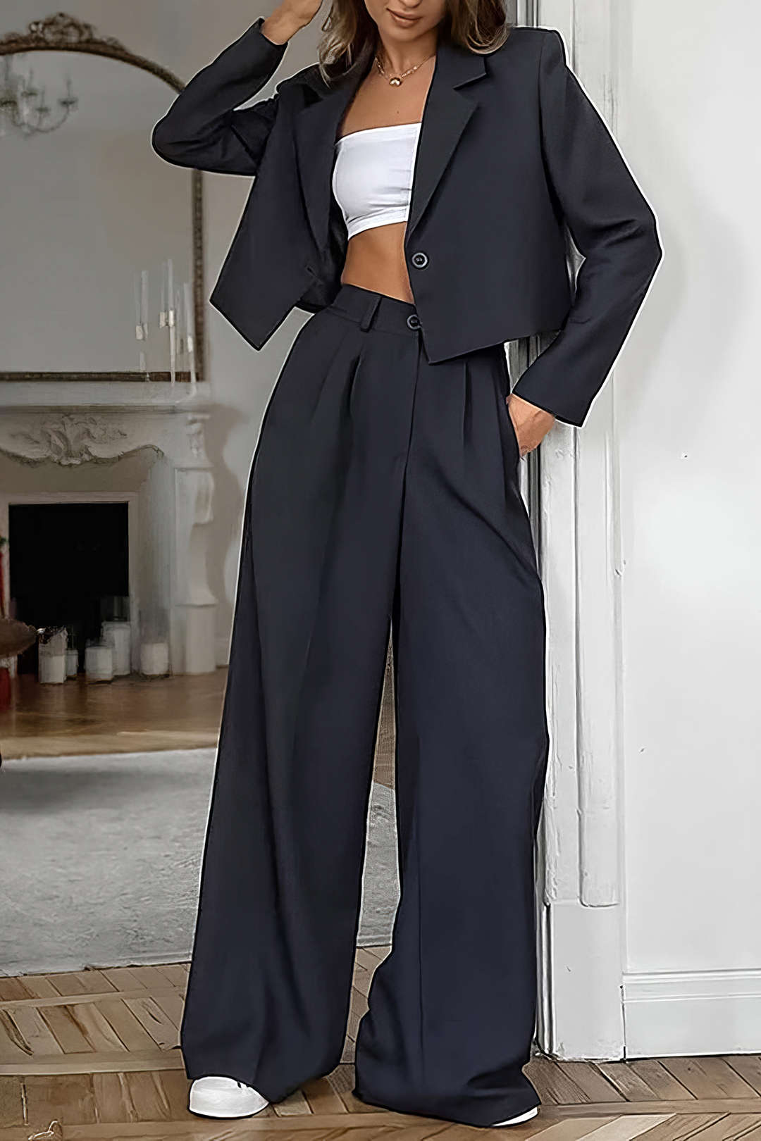 Black cropped blazer with a white top and wide-leg high-waist black trousers, full-length front view
