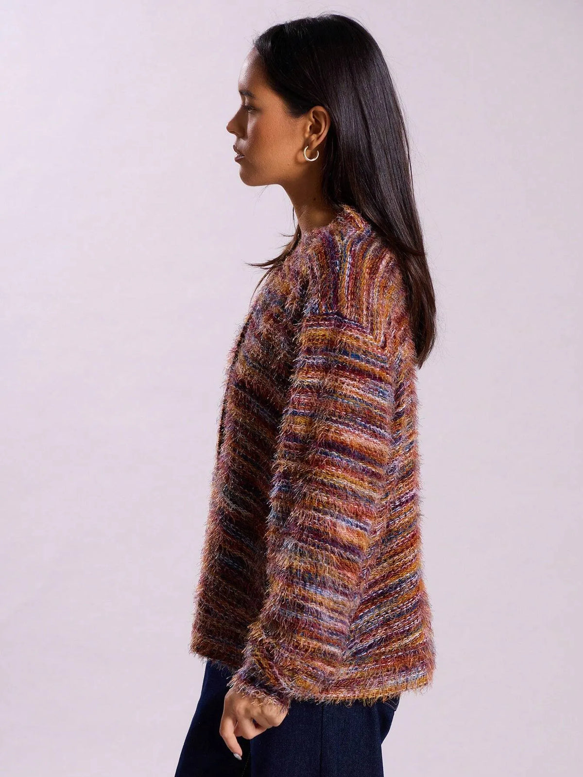 Side view of the multicolor striped knit cardigan with dark jeans