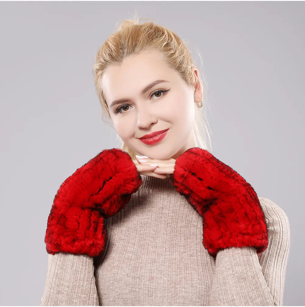 Woman wearing red plush fingerless gloves with her chin resting on her hands