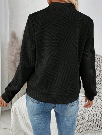 Back view of the black textured bomber jacket with blue jeans