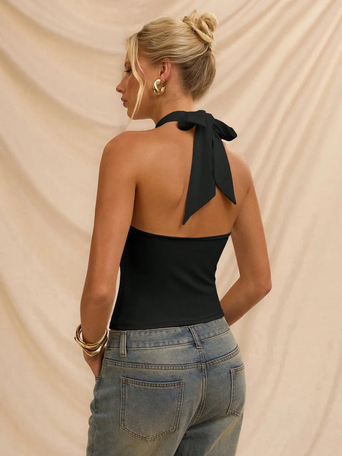 Back view of the black halter top tied at the neck with an open back