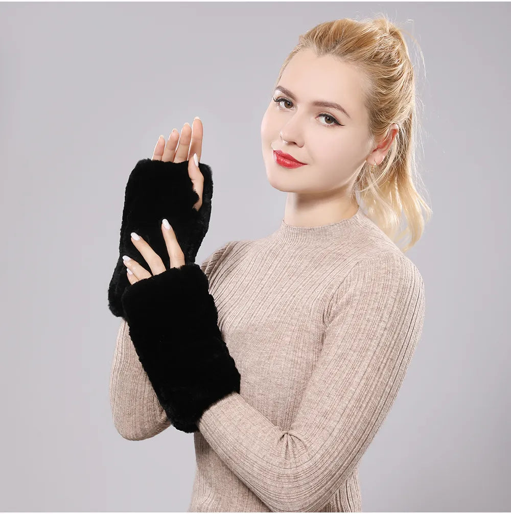 Woman wearing black plush fingerless gloves with one hand raised