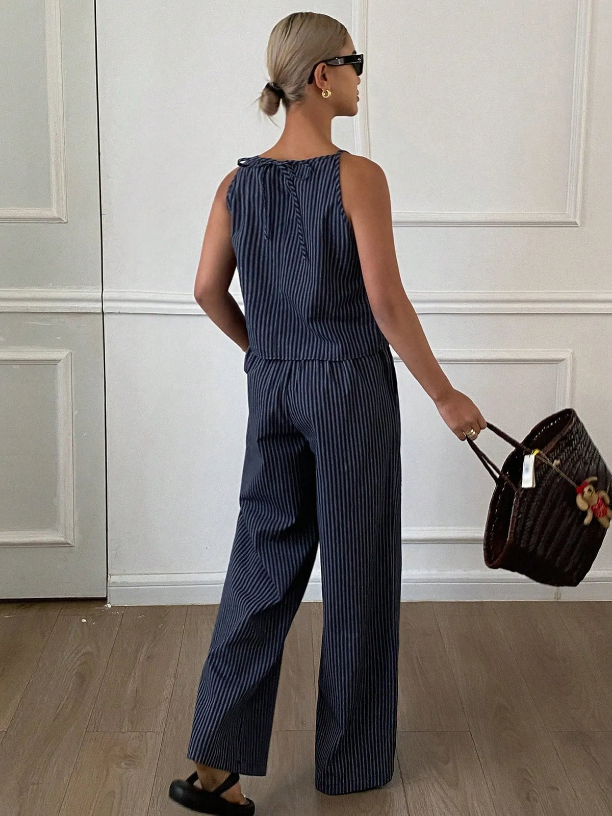 Back view of the navy pinstripe halter-neck top tied at the neck, with matching wide-leg pants