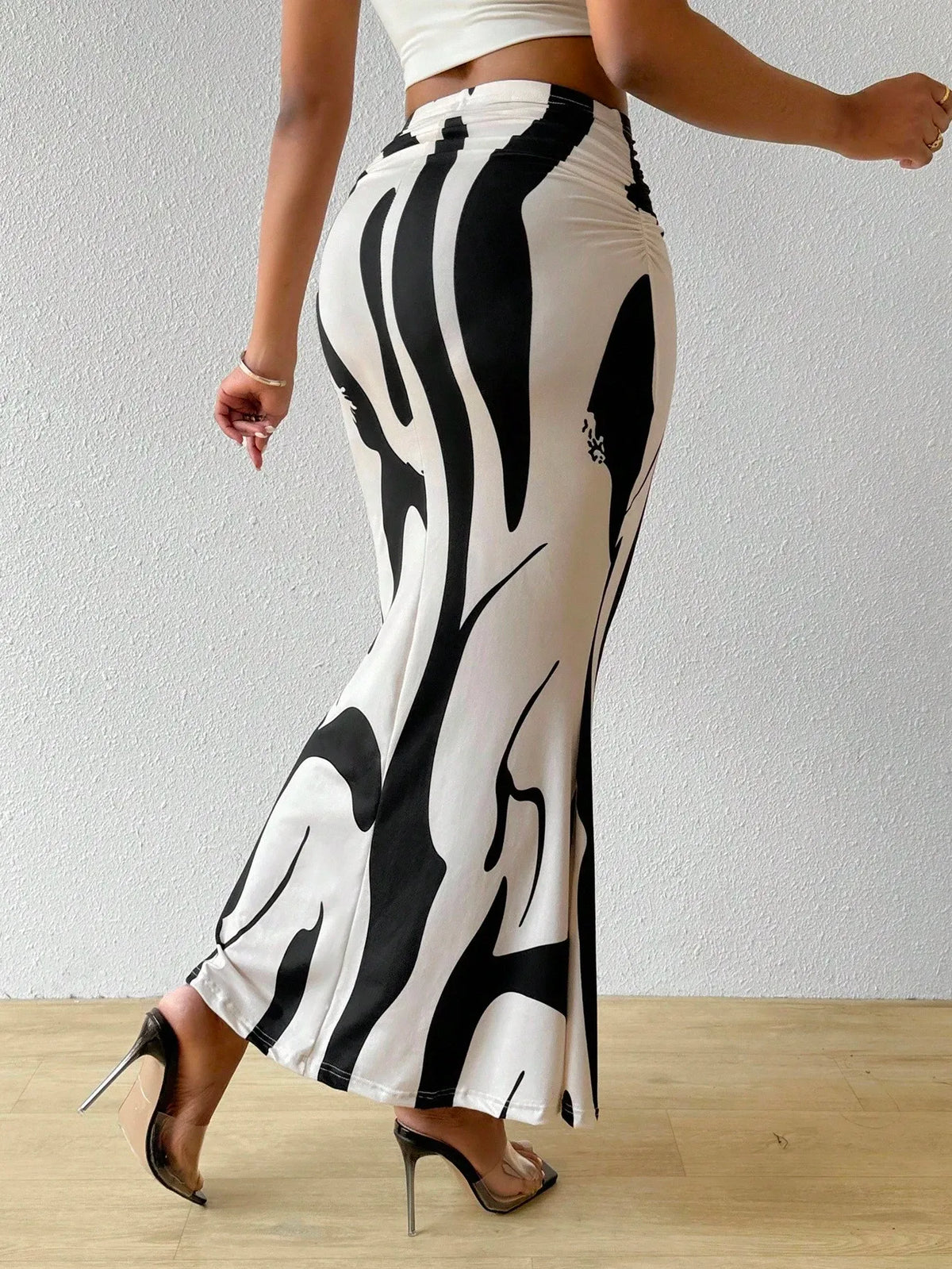 Black and white swirl print maxi skirt in a walking pose with high-heel sandals, side view