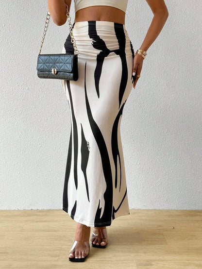 Black and white swirl print maxi skirt worn with a small black textured shoulder bag