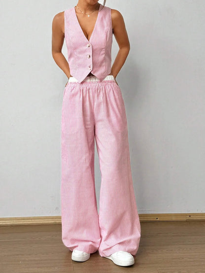 Woman in a pink pinstripe V-neck vest top and matching wide-leg pants with white sneakers, front view