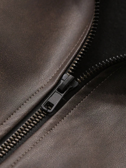 Close-up of the metal zipper and brown leather-look fabric of the jacket