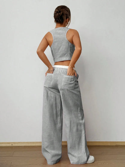Back view of the grey pinstripe vest top and wide-leg pants, hands in the back pockets