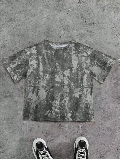 Grey camo print oversized T-shirt laid flat with black sneakers below