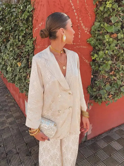 Side view of the cream patterned double-breasted blazer set with a small clutch