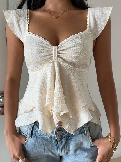 Front view of the cream textured knit top with a sweetheart neckline and layered hem, worn with jeans