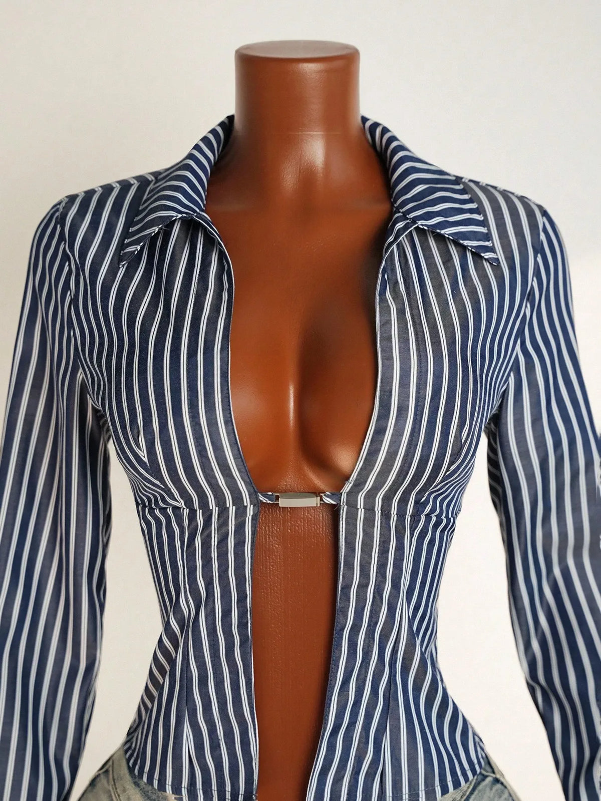 Close-up of the navy and white striped shirt with a metal closure at the center front on a mannequin