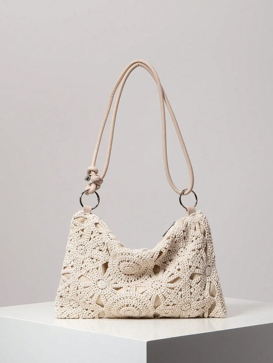 Cream crochet shoulder bag with rope handles and silver ring details, front view on a white pedestal