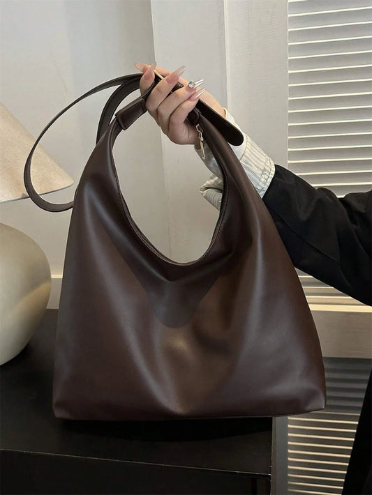 Dark brown slouchy shoulder bag held up by its strap