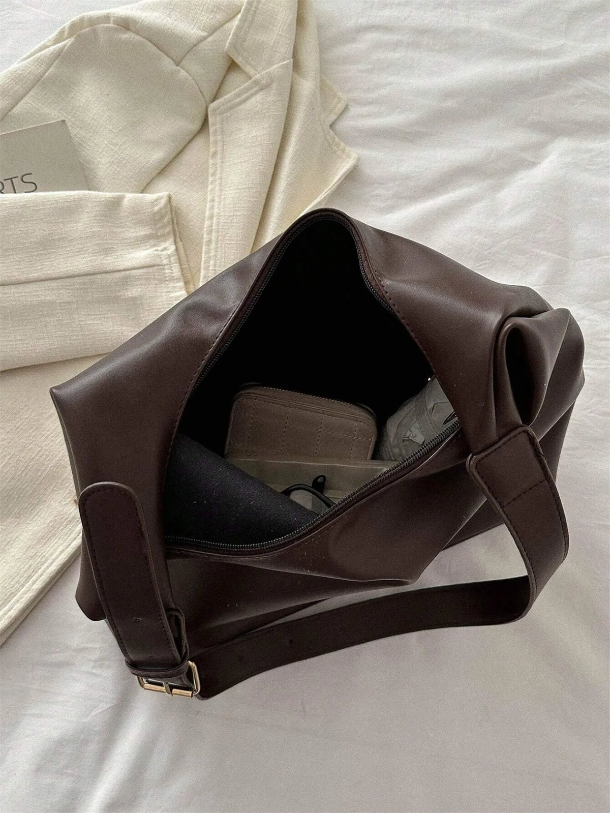 Open top view of the dark brown shoulder bag showing the interior and strap