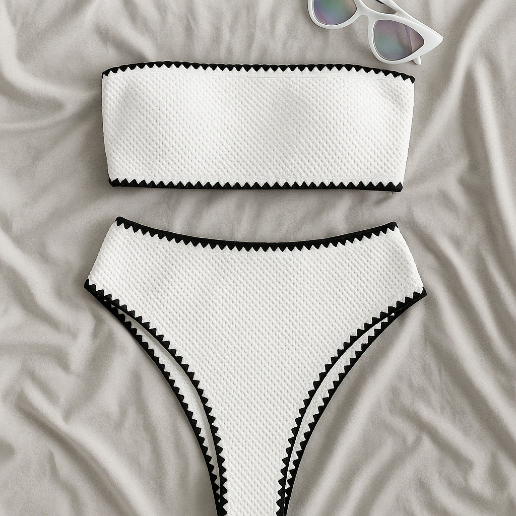 White textured bandeau bikini set with black zigzag trim, laid flat